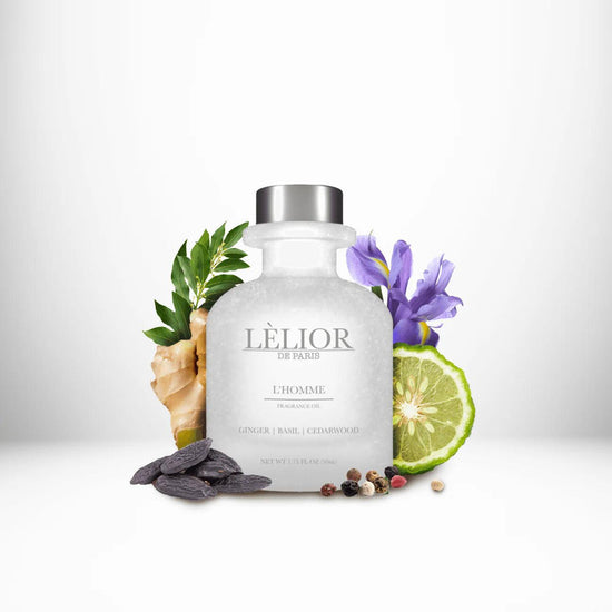 L'HOMME Fragrance Oil displayed with surrounding fragrance notes, featuring a 50mL clear front glass bottle that highlights the rich, aromatic blend.