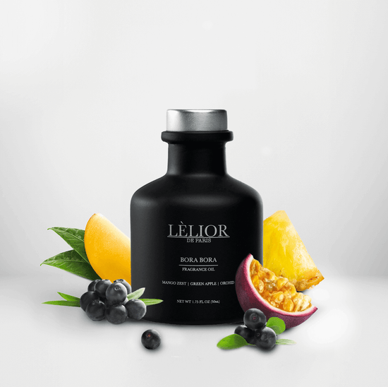 50ml black glass bottle with silver lettering and silver cap. Bora Bora scent with notes of mango zest, green apple, and orchid around the bottle. White background