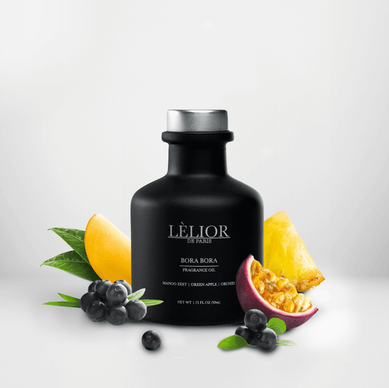 50ml black glass bottle with silver lettering and silver cap. Bora Bora scent with notes of mango zest, green apple, and orchid around the bottle. White background