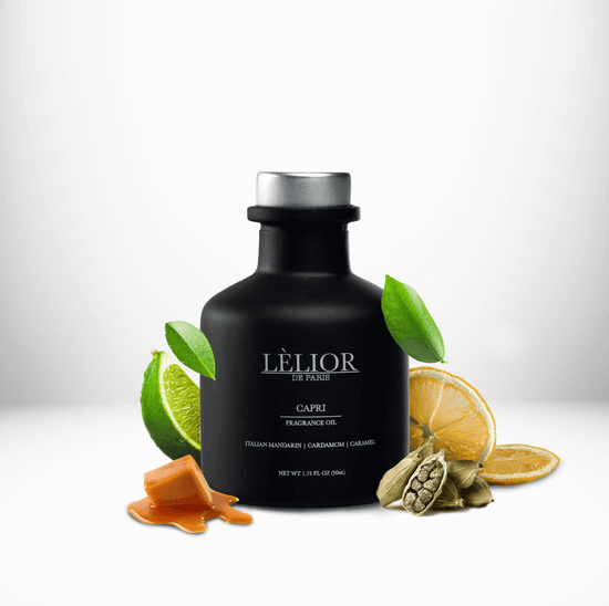 50ml black glass bottle with silver lettering and silver cap. Capri scent with notes of Italian Mandarin, cardamom,  and caramel around the bottle. White background
