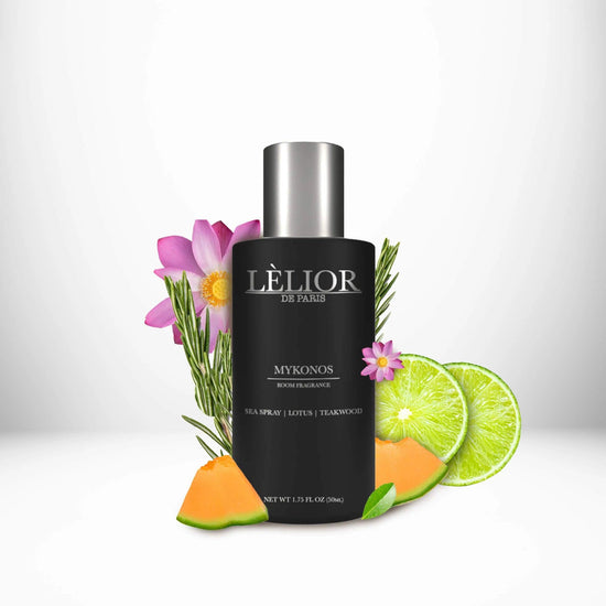 Luxury 50ml black glass room spray bottle with silver lettering and cap. Mykonos scent with notes of sea spray, lotus, and teakwood shown around the bottle. White background.