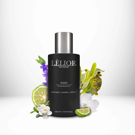 Luxury 50ml black glass room spray bottle with silver lettering and cap. Paris scent with notes of bergamot, jasmine, and vetiver shown around the bottle. White background. 