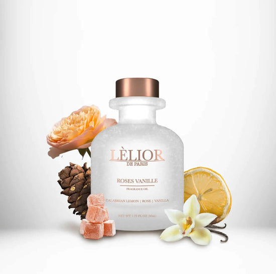Luxury 50ml frost clear bottle with rose gold lettering and cap. Roses Vanille scent with notes of calabrian lemon, rose, and vanilla shown around the bottle. White background.