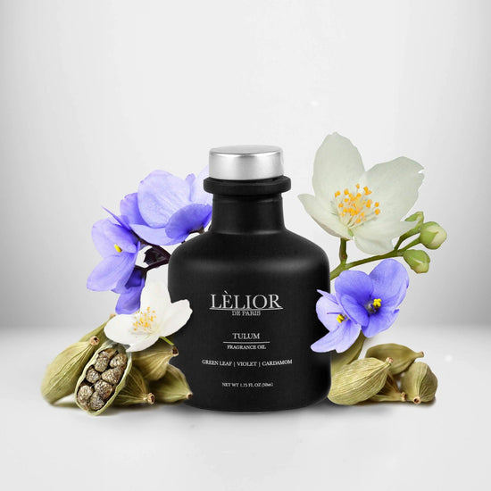 50ml black glass bottle with silver lettering and silver cap. Tulum scent with notes of green leaf, violet, and cardamom around the bottle. White background